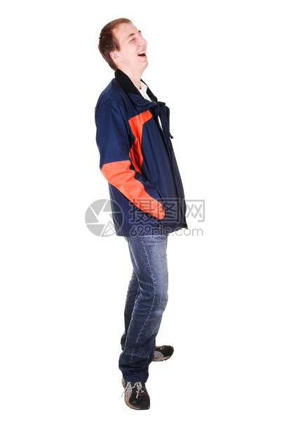 一个穿牛仔裤和蓝色橙夹克的年轻青少站在电视里笑着因为白人背景被孤立图片