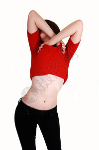 一个瘦的年轻女人带着她的红色毛衣站在镜头前穿着牛仔裤白色背景图片