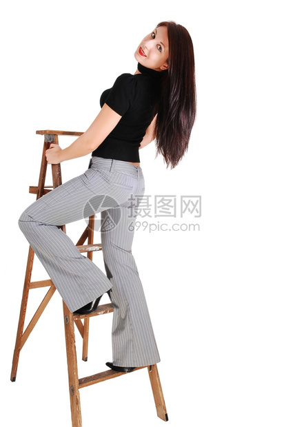 一位年轻女子站在一个穿着灰色裙子裤和黑毛衣的继田阶梯上踏着她美妙的身体图片
