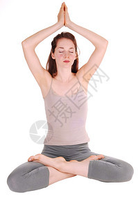 穿着运动服的瘦女孩坐在地板上她的手放在头上腿与瑜伽一起沉思图片
