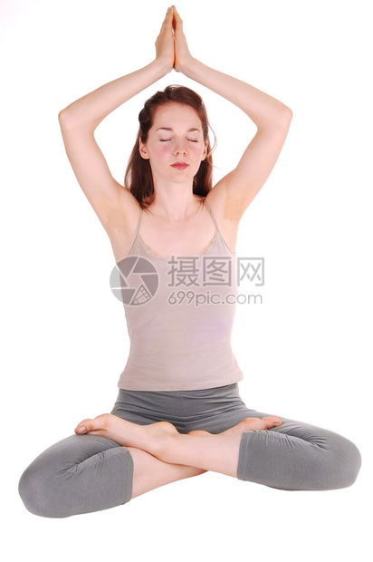 穿着运动服的瘦女孩坐在地板上她的手放在头上腿与瑜伽一起沉思图片