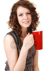 一个可爱的年轻女人手里拿着一个红咖啡杯白底黑图片