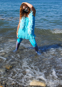 代表水的女人穿着蓝色衣服站在安大略湖岸边阳光明媚海浪冲向岸边图片