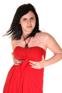 一个穿着红裙子的年轻美女站在工作室里草黑头发在吹走白种背景图片