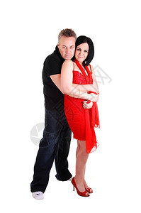 中年夫妇她穿红裙子黑发从她丈夫的背部在白色景得到一个巨大的拥抱图片