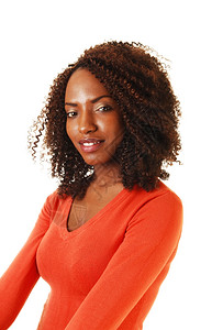 一个美丽的非洲裔国青少年的肖像坐在她长的卷发穿着橙色毛衣白背景图片