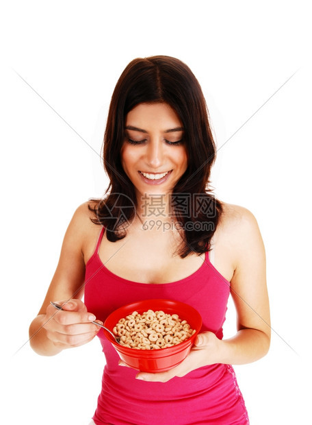 一个漂亮的黑发年轻女人穿着红色T恤手里拿着一碗麦片做早餐图片