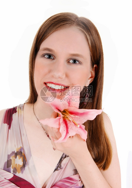 一位年轻美女在肖像照片中手里拿着一只粉红百合微笑着被白种背景隔绝图片
