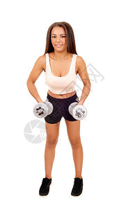 一位穿黑短裤的漂亮女人站在白背景面前举起两个哑铃来锻炼图片
