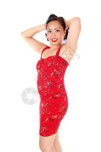 一个可爱的亚洲女人手放在脑后站草裙下被白色背景隔绝图片