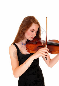 一个长发黑的年轻美女站在白后方玩小提琴图片
