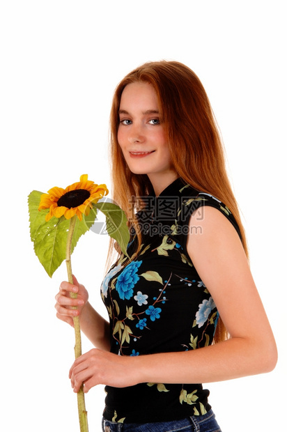 一位可爱的黑发女人手里拿着一朵向日葵站着为白色背景图片