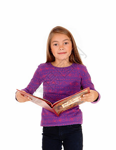 一个金发碧眼的八岁女孩拿着她的故事书被白种背景孤立图片
