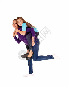 母亲和女儿玩着孤立的白色背景女孩在母亲的背上图片