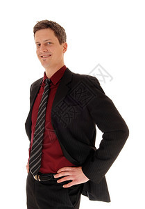 一个穿着西装和领带的商人站着手放在臀部孤立的白背景图片