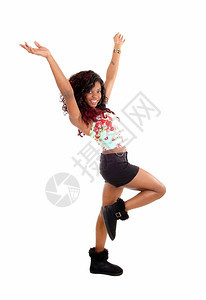 一位非常快乐的裔美国女青年穿着黑色短裤靴子脱下她的胳膊跳舞与白种背景隔绝图片