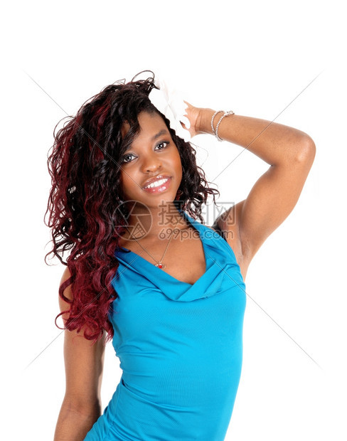 一个可爱的年轻非裔美国女人穿着蓝色的裙子站着为白种背景而孤立一只手在她的头上图片