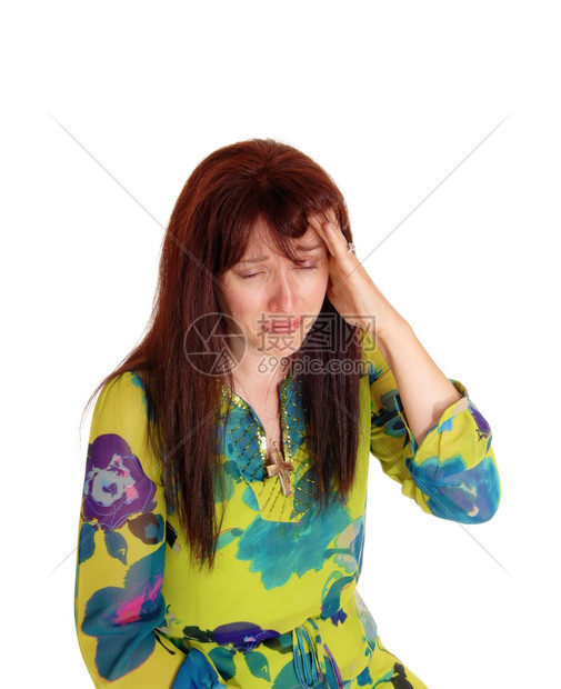 一个中年妇女穿着多彩的裙子头上戴着她的手哭泣头痛孤立白种背景图片