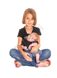 一个小女孩抱着她三个星期的哥在她大腿上坐地板图片