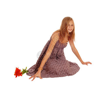 一个穿着勃根底裙子的漂亮小女孩坐在地板上微笑孤立无援的白种背景图片
