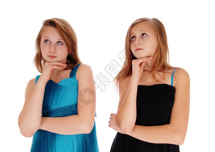 两个身着黑色和蓝礼服的少女手在黑衣下面抬头看孤立的敌人白背景图片