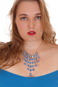 一个金发碧眼的女人穿着蓝色礼服带美丽的蓝宝石项链与白色背景隔绝图片