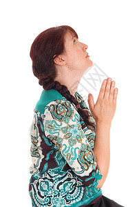 一位美丽的中年女子坐在侧面与她的手祈祷感觉孤立的白色背景图片