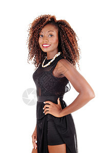 一个可爱的非裔美国年轻女人穿着黑色裙子看镜头与白人背景隔绝图片