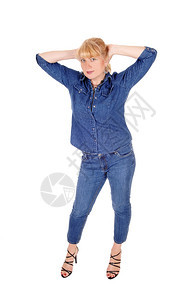 一个穿着牛仔裤和外套的可爱女人站在白背景的隔离处双手放在头上图片