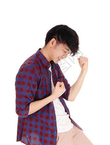 一个快乐的亚裔青少年站在一身格斗的衬衫手握拳头与白种背景隔绝图片