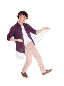 一位穿着格斗衬衫和运动鞋跳舞的亚洲年轻人与白背景隔绝图片