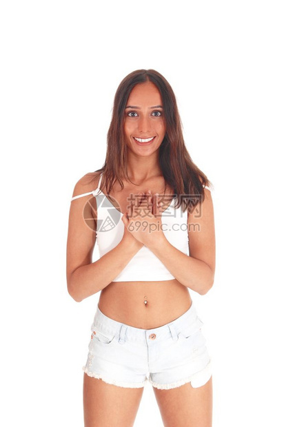 一位非常快乐的年轻女子站在前面穿着短裤和白色的上衣双手放在胸前图片