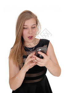 一位穿着黑裙子的金发美女看着她的手机难以置信地看着她的手机图片