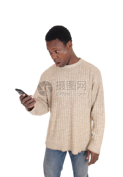 一个英俊的非裔美国人男子站在米衣上看着他的手机在休克中图片