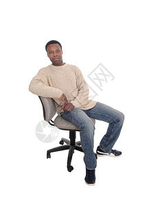 身穿牛仔裤和米色毛衣坐在办公椅子上因白人背景而孤立无援图片