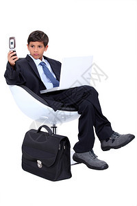 年轻男孩打扮成一个超专业的商人图片
