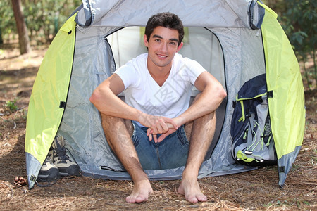 青年露营车在帐篷附近摆姿势背景图片