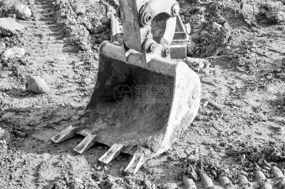 挖掘洞的机械铲土掘在地上用黑白挖洞图片