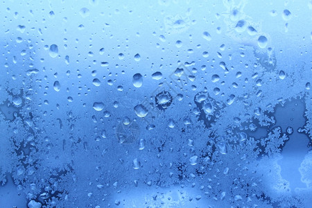 冬季玻璃上的蓝色冰和水滴图片素材