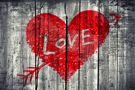 画出抽象的心被一箭刺穿用爱这个词在木墙壁背景上图片