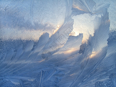 美丽的冰面图案和冬季玻璃上的阳光背景图片