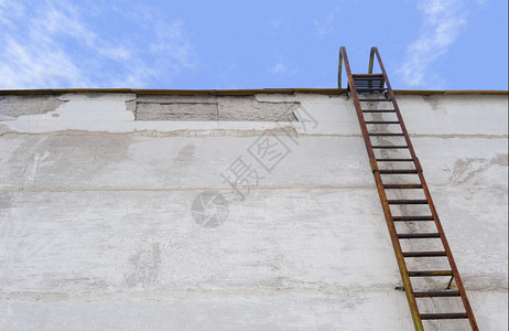 墙上的梯子水泥墙上的老旧生锈梯子图片