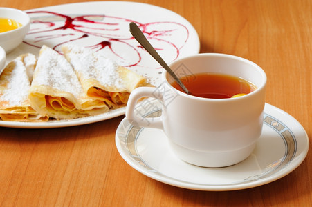 茶和煎饼加奶粉糖菜盘由牛莓果酱装饰图片