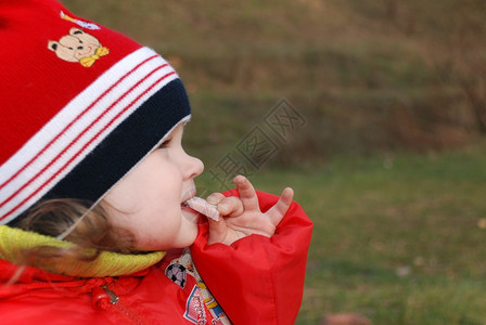 小女孩在草丛吃香肠火腿图片