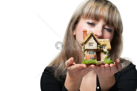 女商人手中握着小房子专注于在白色背景上被孤立图片
