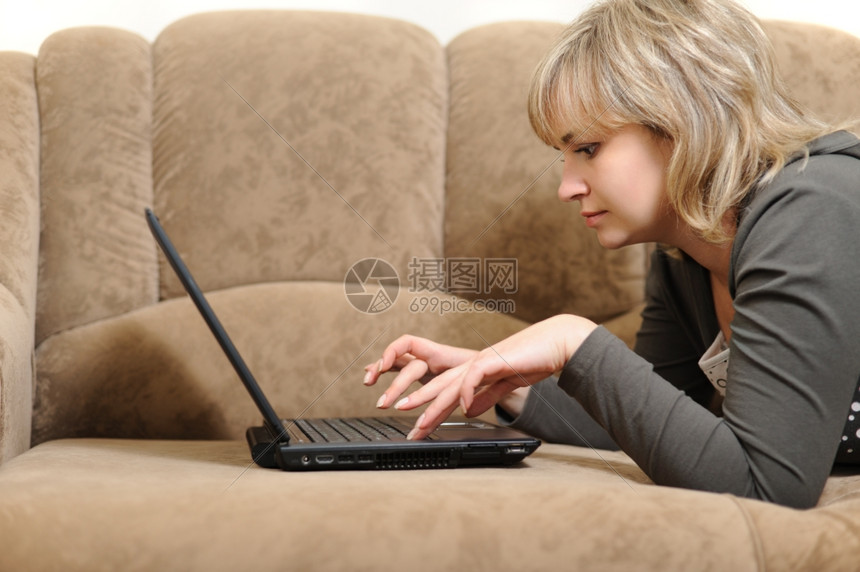 躺在沙发上用笔记本电脑办公的女人图片