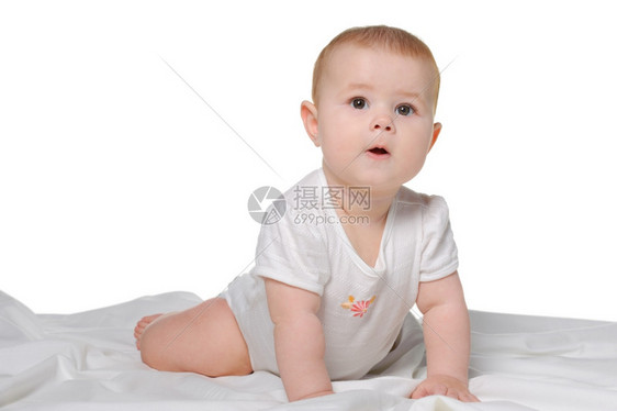 婴儿在床单上8个月大在白色背景上被隔离图片