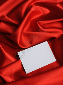 红色丝绸上的注释空纸表格背景图片