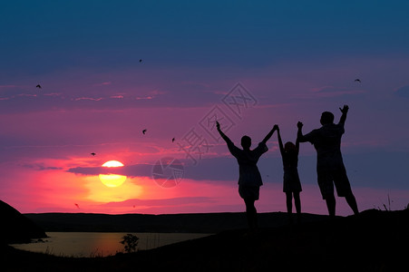 举起的手三个人的家庭欢迎日落太阳背景