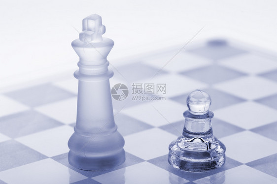 玻璃象棋子和国王蓝色的白隔离在背景上图片